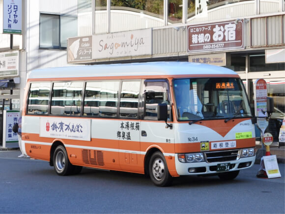 箱根登山と書かれた白とオレンジ色のシャトルバス