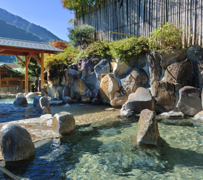 「日帰り温泉 湯の里おかだ」の石に囲まれた露天風呂