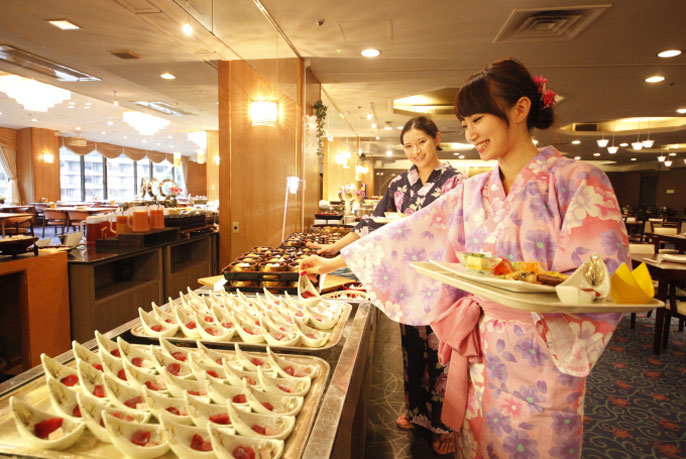 二人の女性がバイキングで食事を選んでいる様子