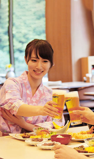 テーブルでビールを持ち上げて乾杯する女性