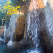 大きくそびえ立つ岩から流れる打たせ湯