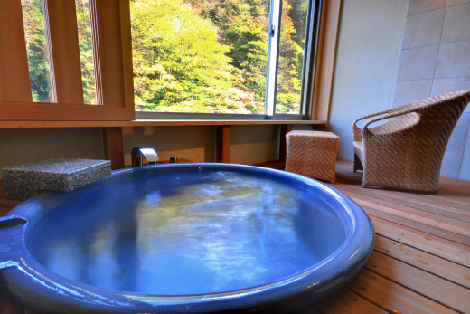 木造のお部屋の内湯と窓からは緑豊かな景色